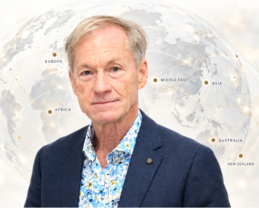 Professor Jay Hays with a globe showing Europe, Africa, the Middle East, Asia, Australia and New Zealand